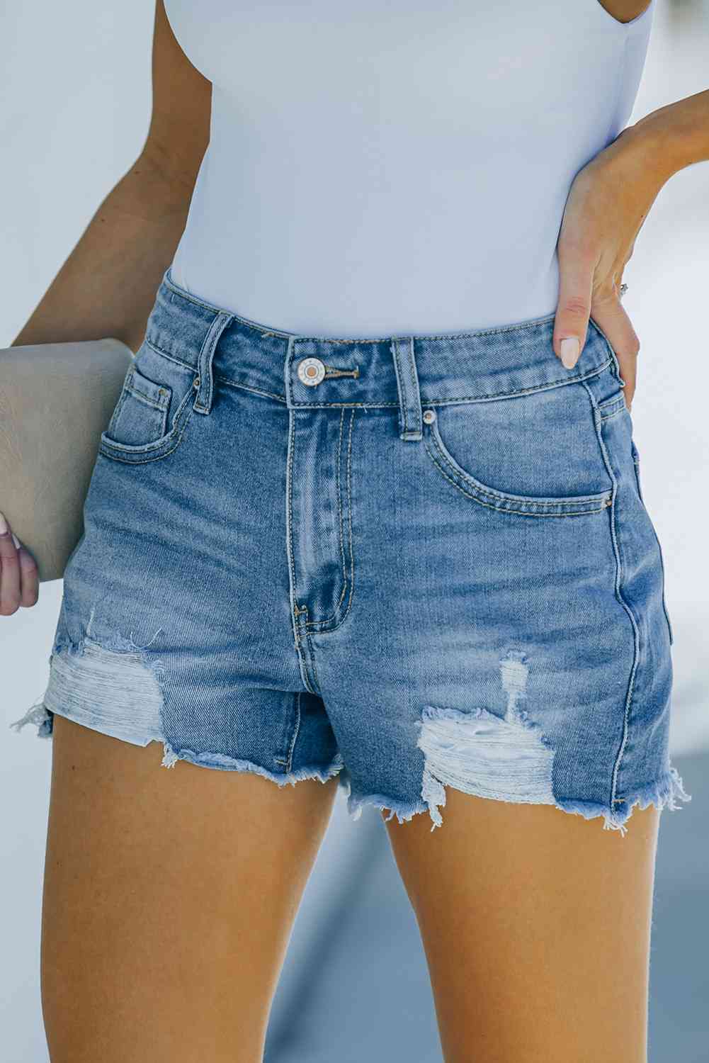 Shorts de mezclilla desgastados con dobladillo deshilachado y bolsillos