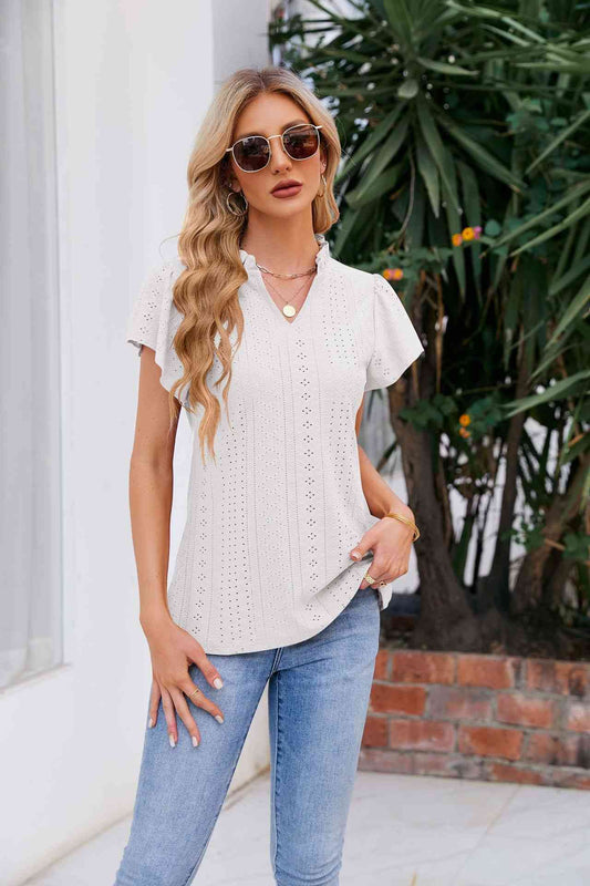 Blusa con mangas abullonadas y cuello con muescas