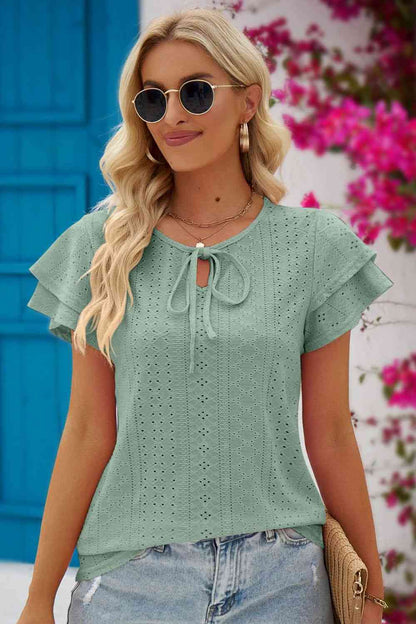 Blouse à manches flottantes et col noué à œillets