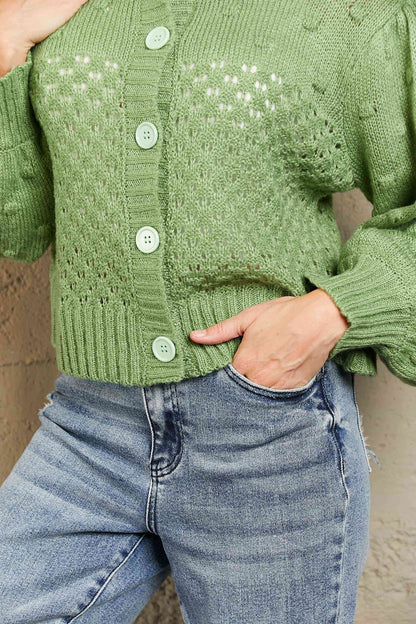 Cardigan tissé à manches bouffantes et pompon ajouré à droite