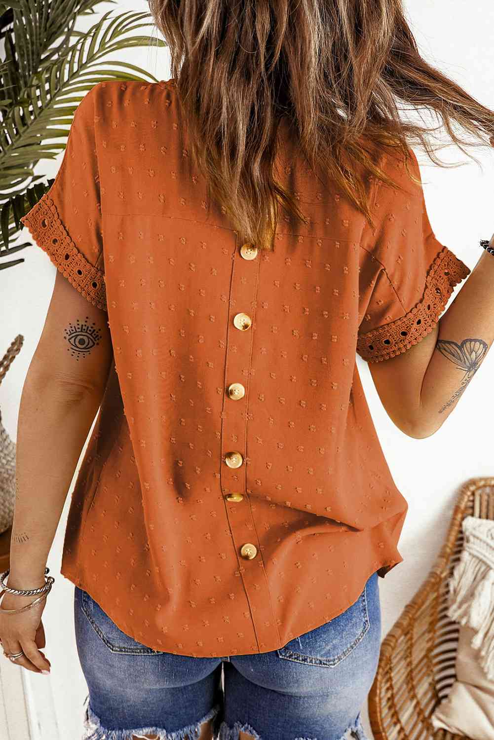 Blusa de manga corta con botones decorativos y lunares suizos