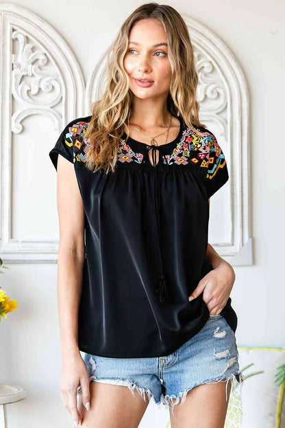 Blusa bordada con borlas y cuello anudado