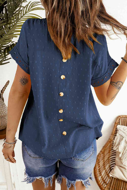 Blusa de manga corta con botones decorativos y lunares suizos