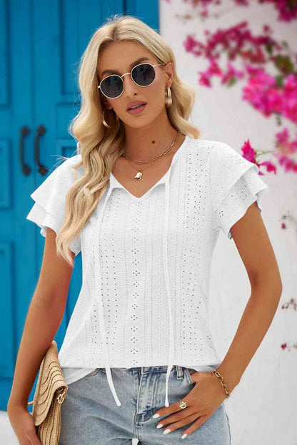 Blouse à manches flottantes et col noué à œillets