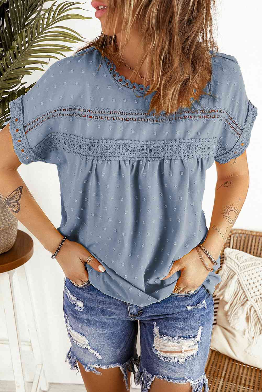 Blusa de manga corta con botones decorativos y lunares suizos