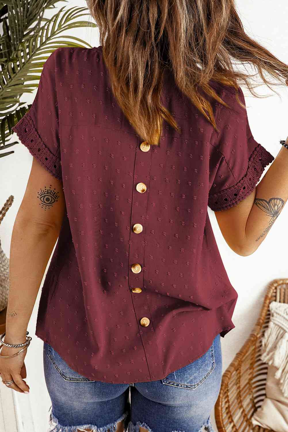 Blusa de manga corta con botones decorativos y lunares suizos