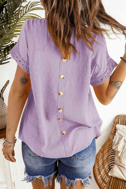 Blusa de manga corta con botones decorativos y lunares suizos