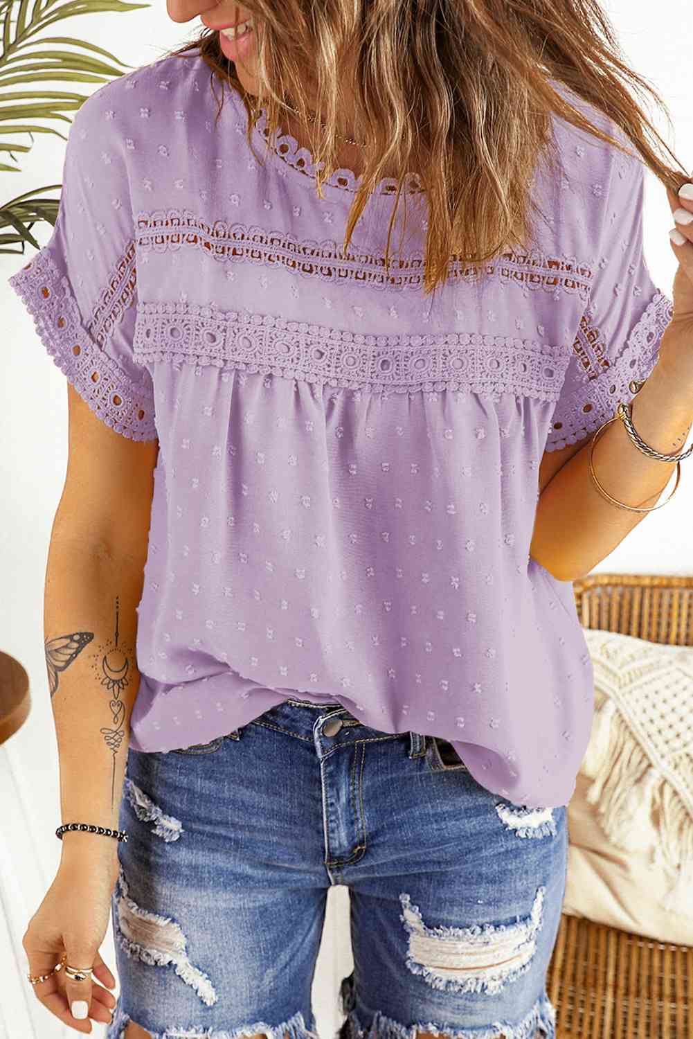 Blusa de manga corta con botones decorativos y lunares suizos