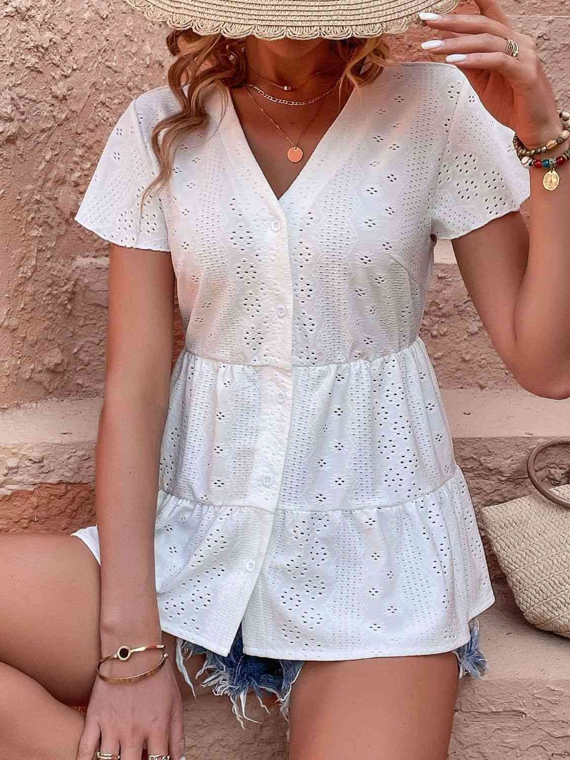 Blouse à volants et manches flottantes avec œillets et boutons sur le devant