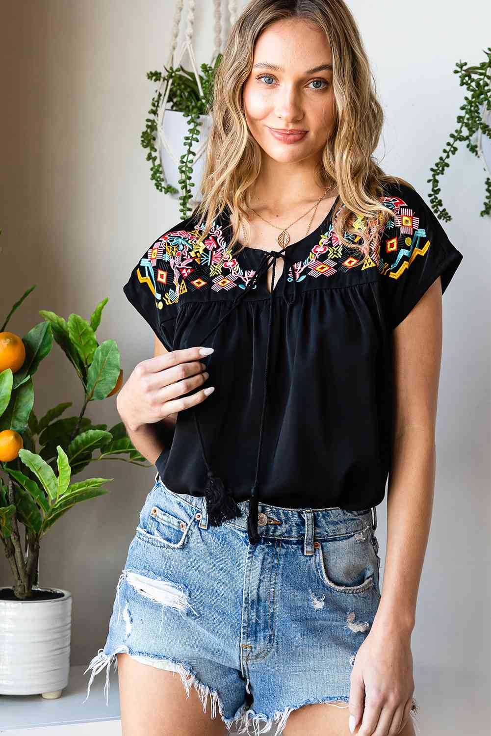 Blusa bordada con borlas y cuello anudado