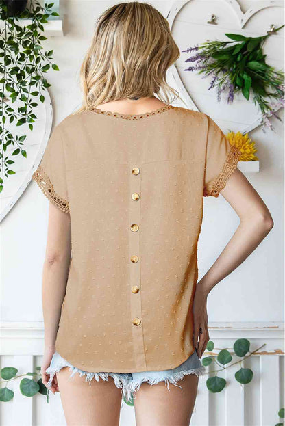 Blusa de manga corta con botones decorativos y lunares suizos