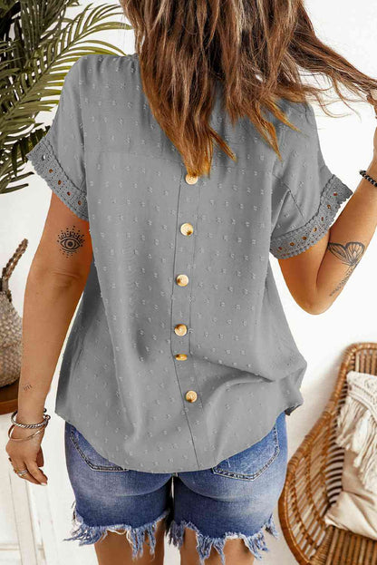 Blusa de manga corta con botones decorativos y lunares suizos