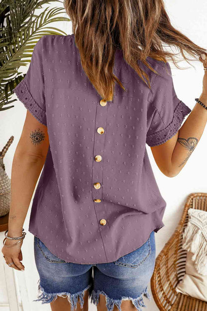 Blusa de manga corta con botones decorativos y lunares suizos