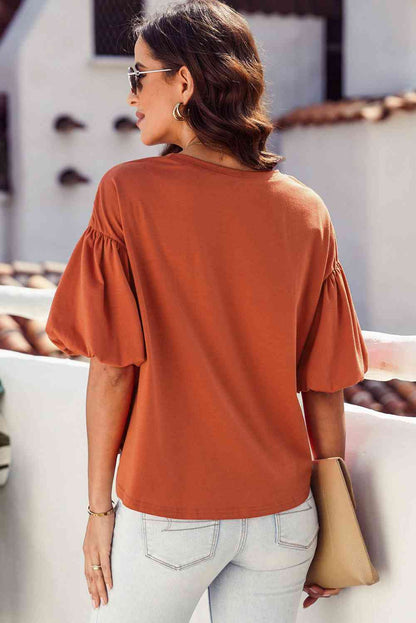 Blouse à manches bouffantes et ourlet arrondi