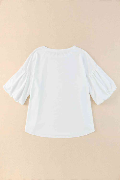 Blouse à manches bouffantes et ourlet arrondi