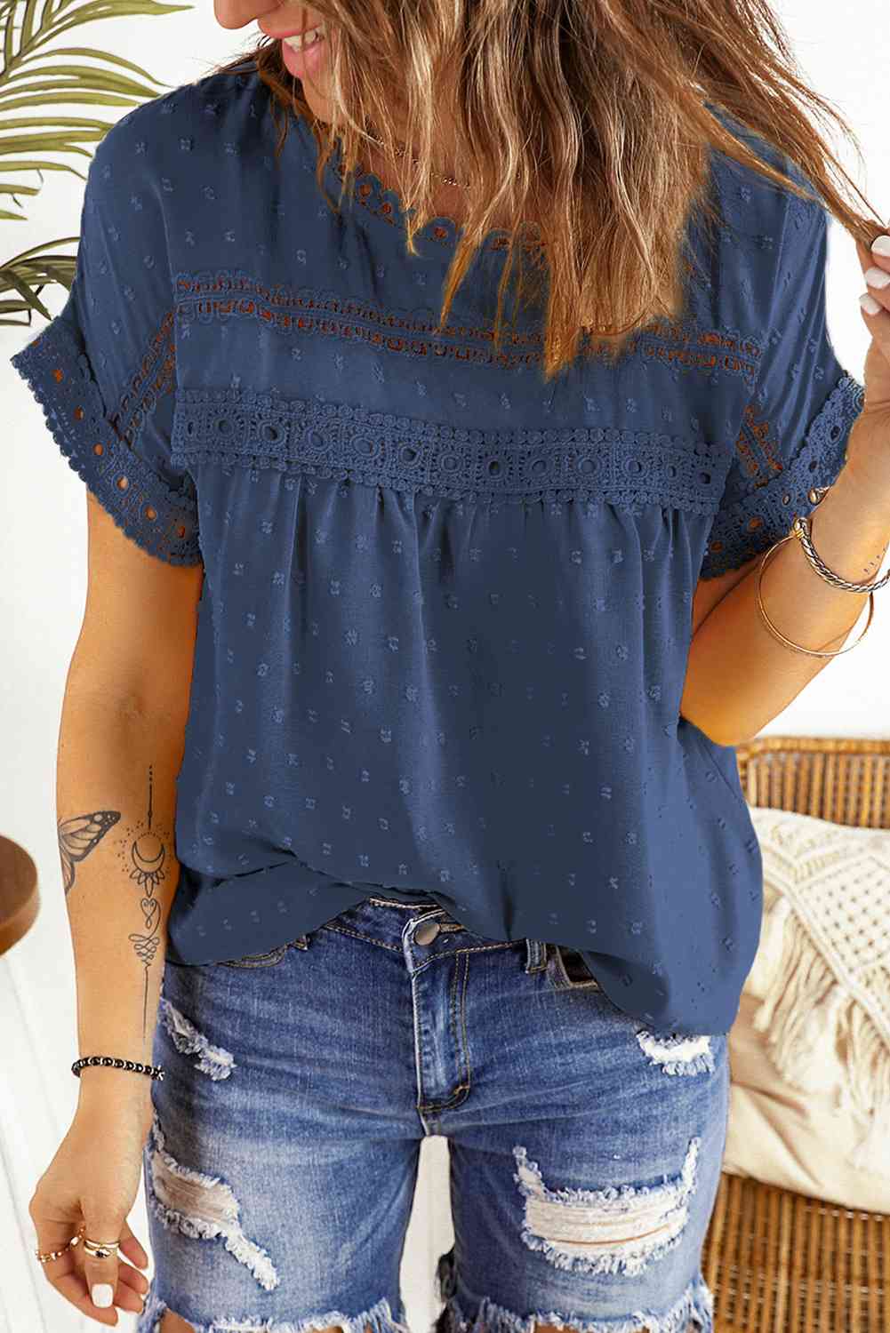 Blusa de manga corta con botones decorativos y lunares suizos