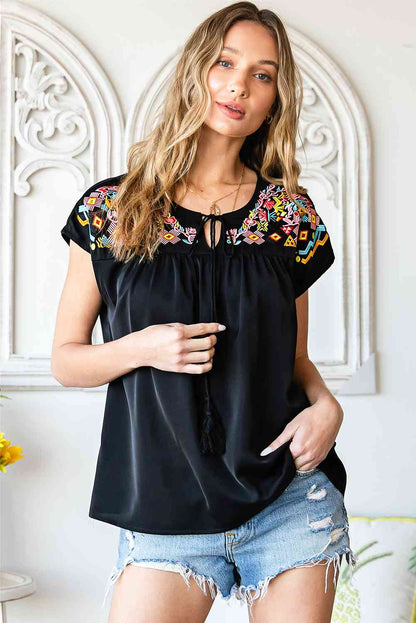 Blusa bordada con borlas y cuello anudado