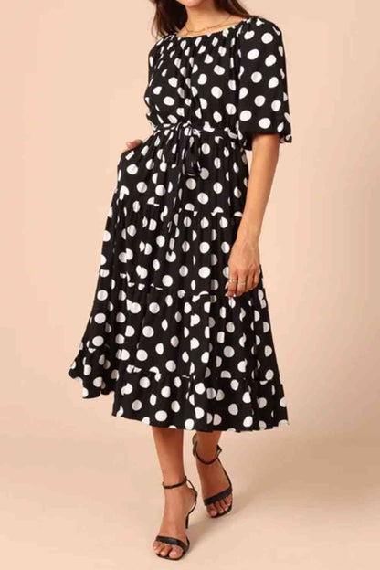 Robe mi-longue à pois et nouée à la taille