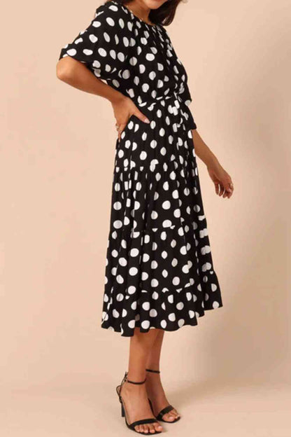 Robe mi-longue à pois et nouée à la taille