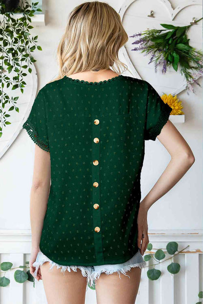 Blusa de manga corta con botones decorativos y lunares suizos