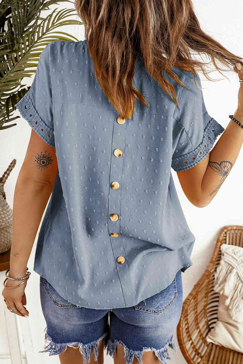 Blusa de manga corta con botones decorativos y lunares suizos