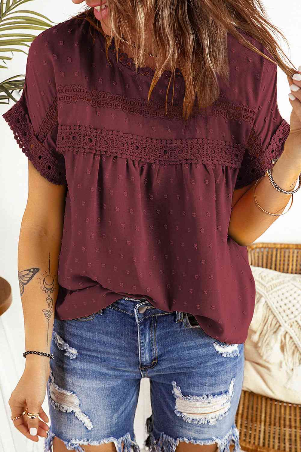 Blusa de manga corta con botones decorativos y lunares suizos