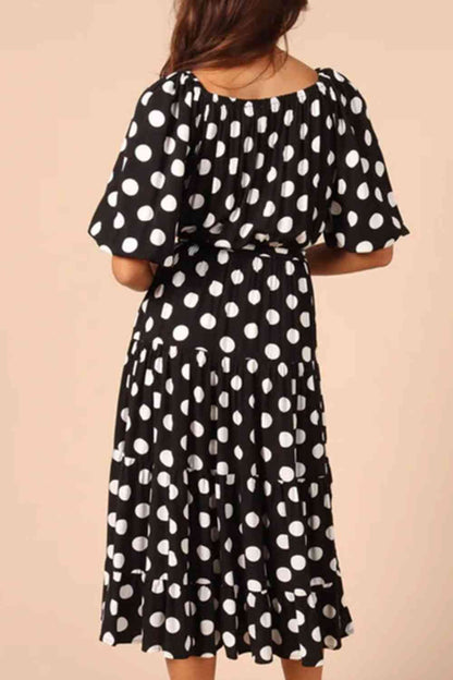 Robe mi-longue à pois et nouée à la taille