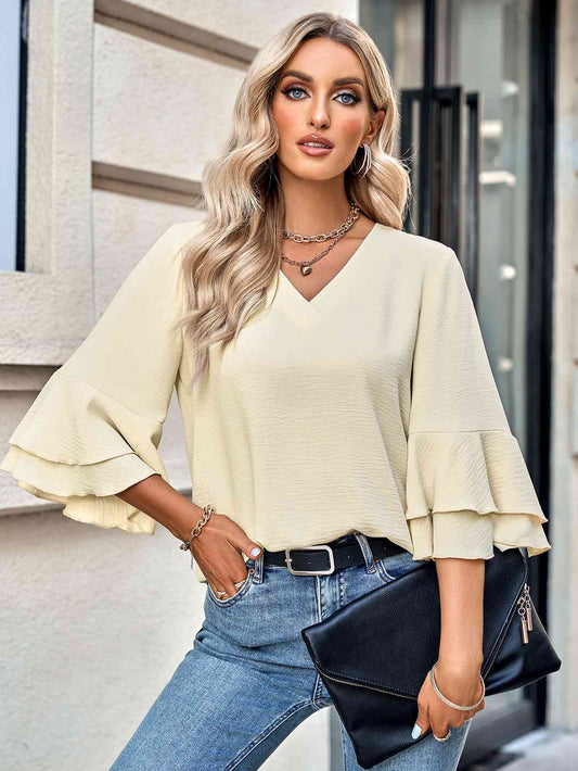 Blusa con cuello en V texturizada y mangas acampanadas en capas