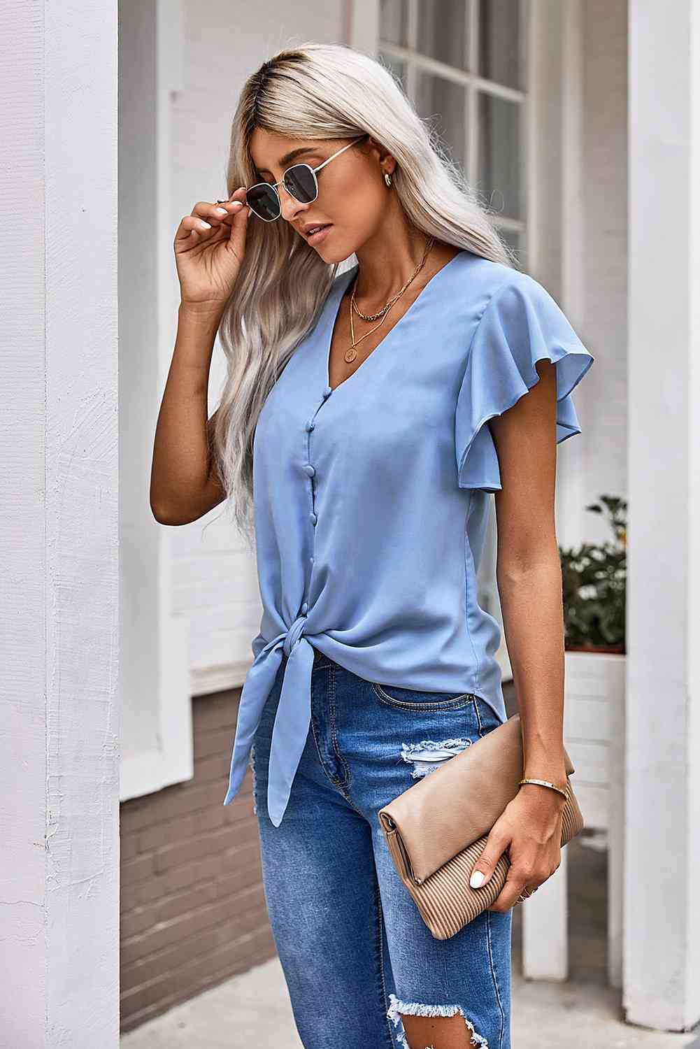 Blusa con mangas acampanadas y dobladillo anudado con cuello en V