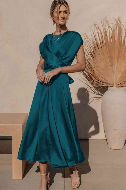 Robe mi-longue en satin à manches courtes et nouée au dos