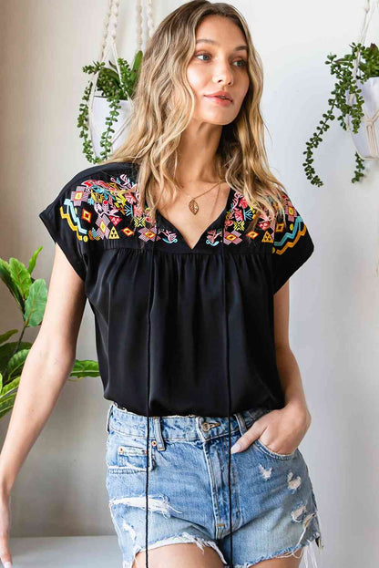 Blusa bordada con borlas y cuello anudado