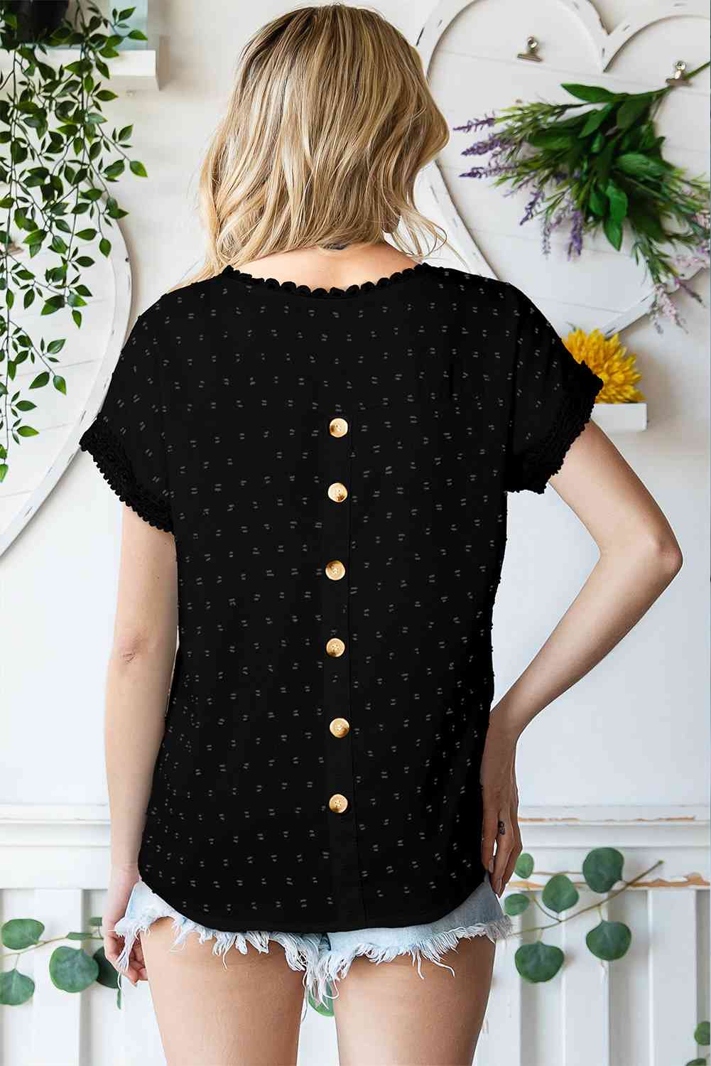 Blusa de manga corta con botones decorativos y lunares suizos