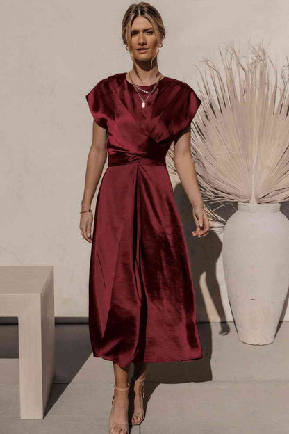 Robe mi-longue en satin à manches courtes et nouée au dos