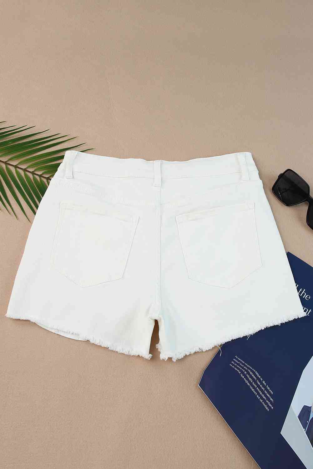 Shorts de mezclilla desgastados con dobladillo deshilachado y bolsillos