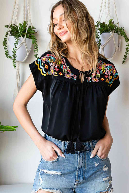 Blusa bordada con borlas y cuello anudado