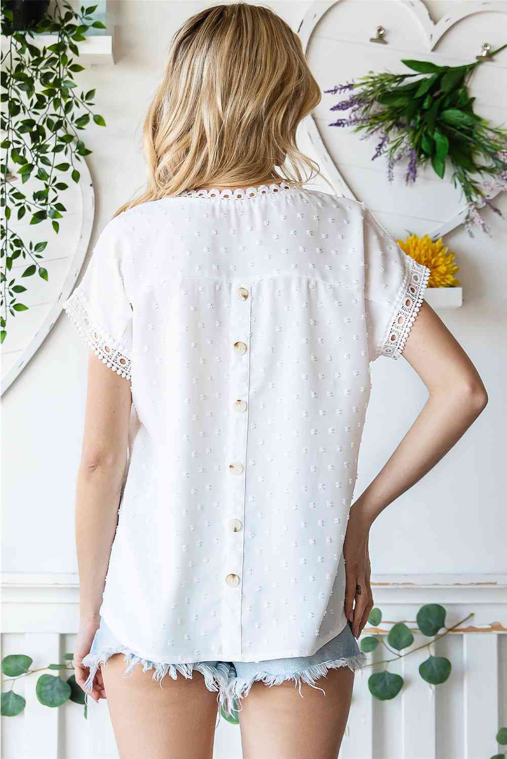 Blusa de manga corta con botones decorativos y lunares suizos