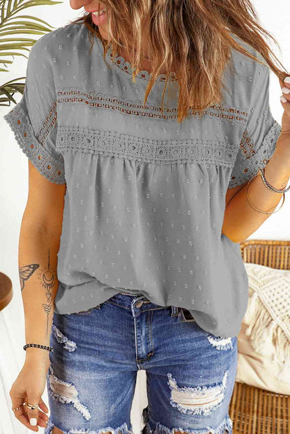 Blusa de manga corta con botones decorativos y lunares suizos