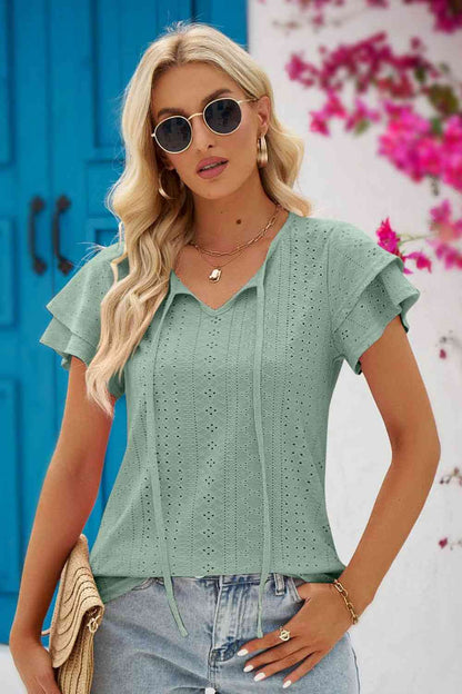 Blouse à manches flottantes et col noué à œillets